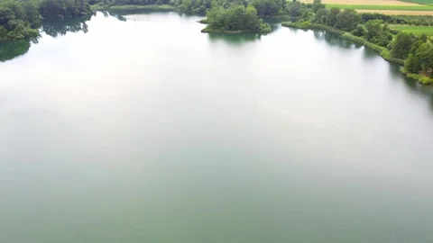 Drone captures cloudy sky reflecting of calm surface of a lake in countryside Stock Footage 269164791