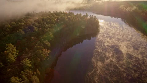 Drone captures ethereal mist lifting from water at daybreak. Stock Footage 321394110
