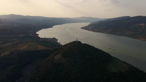 Drone captures a ferry sailing across river Danube and leaving a trail in sunset Stock Footage 263143769