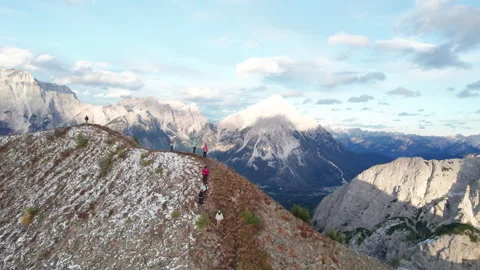 Drone captures hikers descending along snow-covered mountain slope with vast Stock Footage 346770304