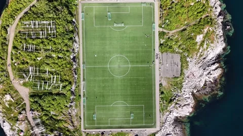 Drone captures island field. High altitude shot showcasing circular soccer pitch Stock Footage 327917645