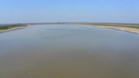 Drone captures large lake as group of birds fly above it in nature reserve Stock Footage 270501970