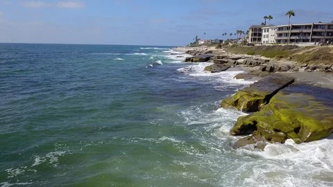 Drone captures ocean waves crashing on rocks on a sunny San Diego summer day Stock Footage 97972758
