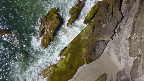 Drone captures ocean waves crashing on rocks on a sunny San Diego summer day Stock Footage 97973289