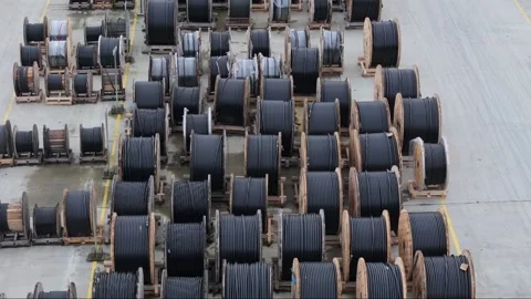 A drone captures the organized layout of wooden cable drums in an outdoor s.. Video stock 259379130