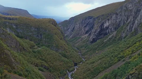 Drone captures powerful falls amid forest and rocks in Eidfjord Stock Footage 320245661