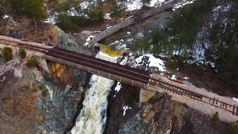 Drone captures a rail bridge over a fast mountain stream in winter Stock Footage 263241264
