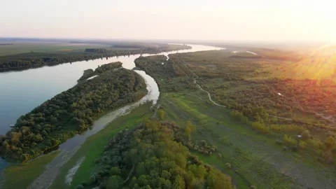 Drone captures river Danube and land surrounding it with meadows and woods in Stock Footage 258954997
