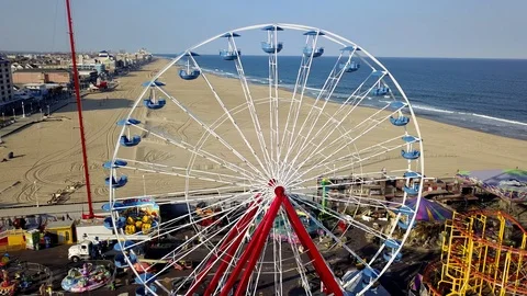 Drone captures running ferris wheel and amusement rides on the Ocean City Pier Stock Footage 89450004