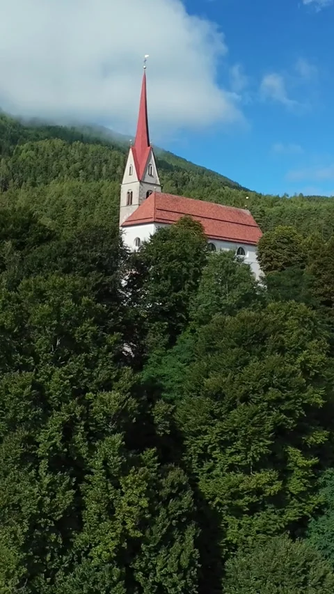 Drone captures scenic view, Secluded church among lush trees, Elevated shot of 스톡 동영상 323890744