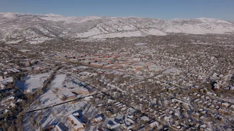 Drone captures serene snow-covered mountains and town landscape in winter Stock Footage 288905994