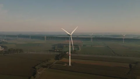 A drone captures several windmills in a field in the fog Stock Footage 274301177
