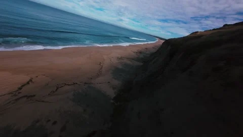 Drone captures slow motion waves rolling onto smooth sand Stock Footage 340905510