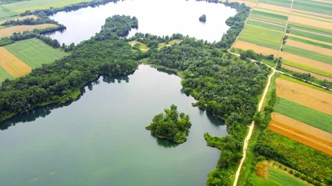 Drone captures small lakes in the middle of vast colorful agricultural fields Stock Footage 269165627