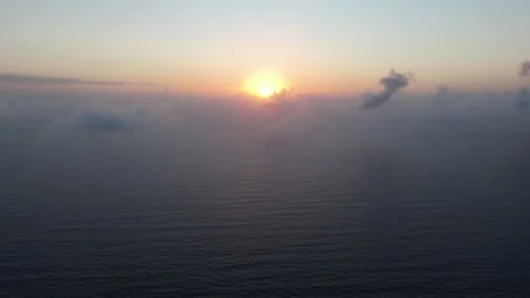 A drone captures the sunrise from inside the clouds, passing through to rev.. Stock Footage 286054857