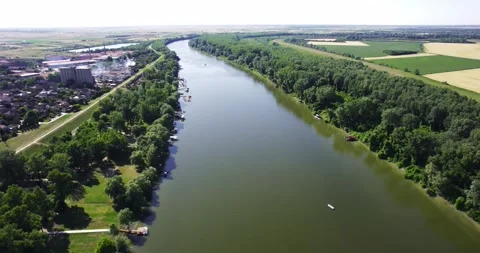 Drone captures a town on one side and fields on other side of Tisza river in Stock Footage 266158250