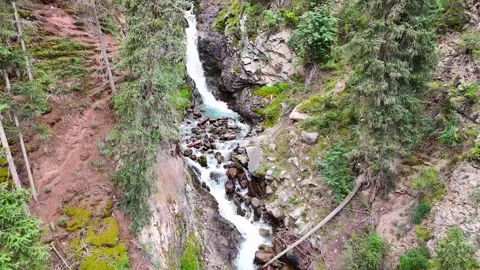 Drone captures waterfall and flows downstream to reveal forest stream bed. Stock Footage 316227354