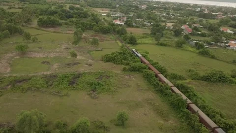A drone chases a freight train as it passes a Vietnamese village. Video stock 255688584
