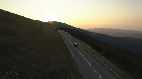 Drone chasing black car driving along asphalt mountain pass Video stock 158978354