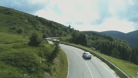 Drone chasing silver sedan on curvy mountain road Stock Footage 157534614