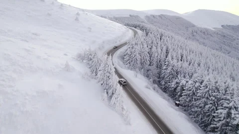Drone chasing silver SUV speeding uphill on winter road, aerial view Vídeo Stock 168171579