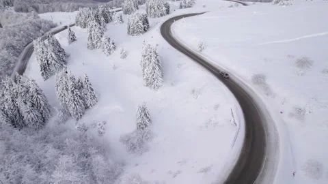 Drone chasing SUV on curvy winter road traveling for Christmas Holidays Stock Footage 168135816