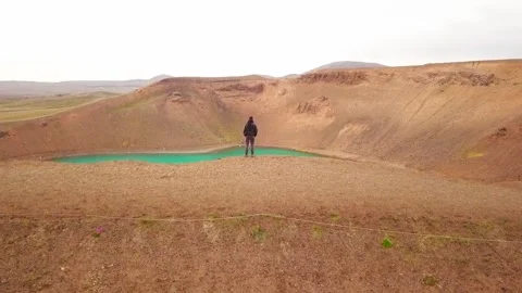 Drone cinematic shot man standing on mountain myvatn Iceland blue lake, 2K Stock Footage 148753203