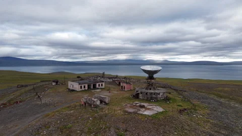 Drone circles abandoned Orbita complex with sea bay and mountains in Chukotka Stock Footage 327121642