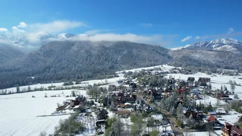 A drone circles above a suburban, snow-covered mountain village Stock Footage 274635504
