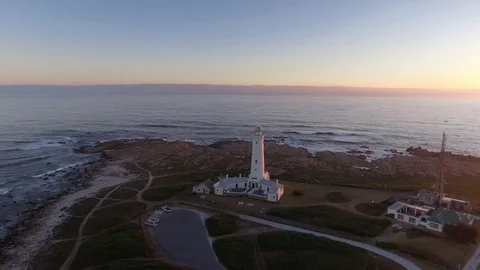 Drone circles around Cape Saint Francis lighthouse during golden sunset Vídeo Stock 85159193