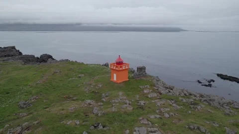 Drone Circles Around Small Orange Light House Dalatangaviti. On Rocky Cliffs Stock Footage 256693016