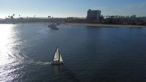 Drone circles around small sailboat in middle of bay on sunny day in San Diego Stock Footage 97201248