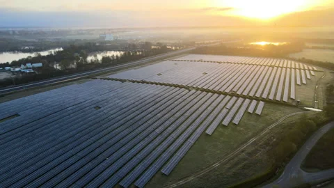 Drone circling around solar farm during early morning sunrise Stock Footage