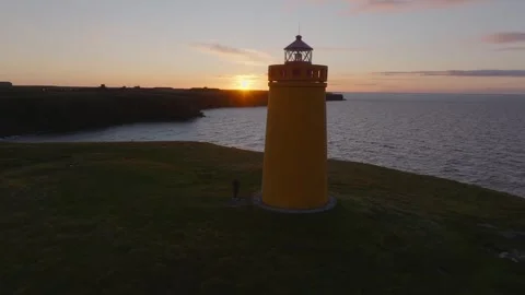 Drone circling around Yellow lighthouse, vivid sunset in Iceland Stock-Footage 330896745