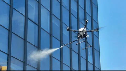 Drone cleaning skyscraper windows with high pressure water spray Stock Photos