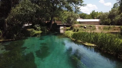 Drone clip flying forward just above the crystal clear moving river Tirino Stock Footage 113345838