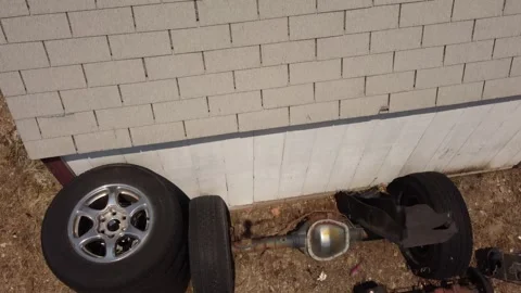 Drone clip looking down on car truck axle rear end sitting on ground with Stock Footage 155093792