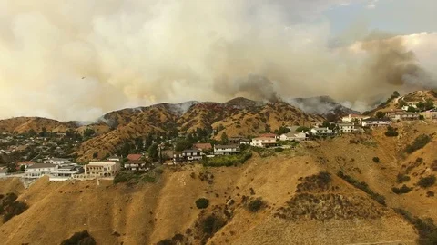 Drone clip over large wildfire moving through neighborhood Stock-Footage 95768484