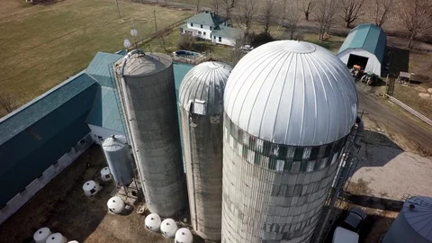 Drone close flyover quebec dairy farm silos and house in spring Stock Footage 93362979