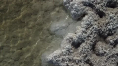 Drone close-up of salt crust formations and texture on the edge of saline lake Stock Footage 319538367