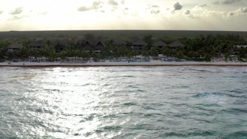 Drone closes in on luxury Tulum resort, flying over the water at sunset Stock Footage 294626418