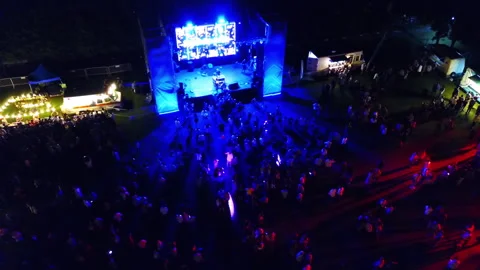 Drone concert stage with crowd circular flight 50 mts 45 degree night Stock Footage 247944119