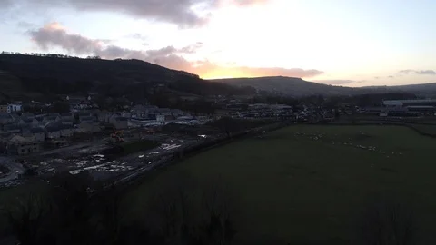 Drone Construction site coming into view near a field full of sheep at sunset Stock-Footage 93422443
