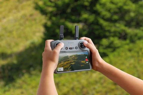 Drone controller showing a live aerial landscape feed, used for filming, ma.. Stock Photos
