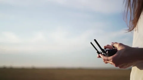 Drone controller in women's hands against a beautiful sky. Copyspace for your Stock Footage 139890732