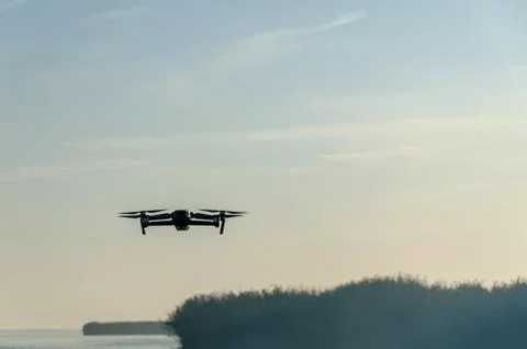 Drone copter with digital camera, blur river on background. Stock Photos