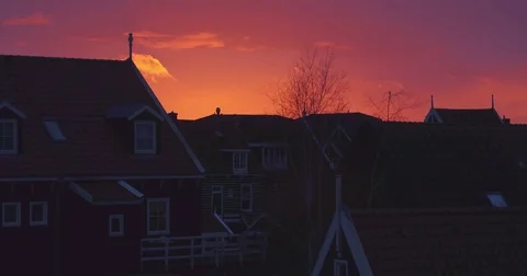 Drone crane shot of sunset in marken filming old fishing houses and harbor Video stock 70895125