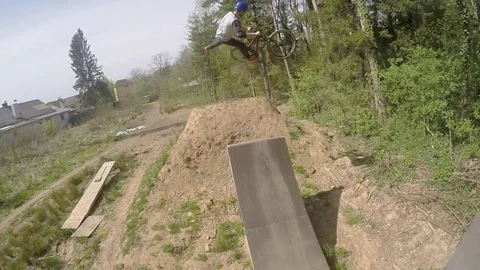 Drone crashes into the landing while filming a mountain biker doing tricks Stock Footage 74143700