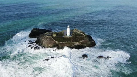 Drone with crashing waves over light house island Stock Footage