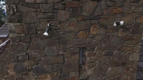 Drone descending along a rustic stone building wall Stock Footage 341902823